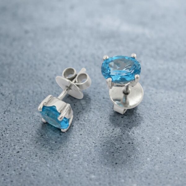 Topos en Oro Blanco Ley 18 kt  con Topacio Azul